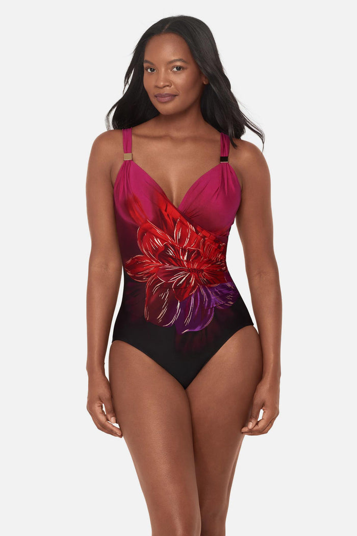 Woman wearing a red, pink and purple floral printed one-piece swimsuit