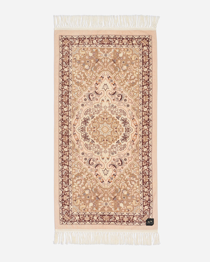 Flat lay of the Slowtide Haven Beach Towel in fawn, showing an ornate Persian medallion pattern in cream and burgundy tones with fringe detail.