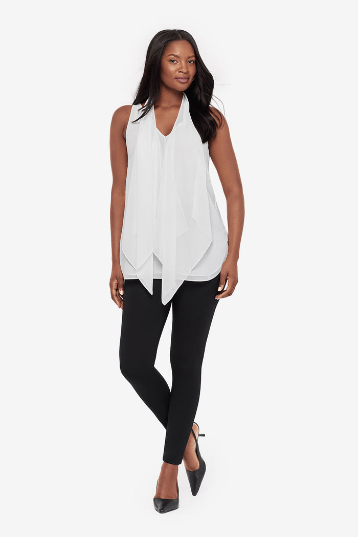 Woman wearing a white tunic blouse with black leggings