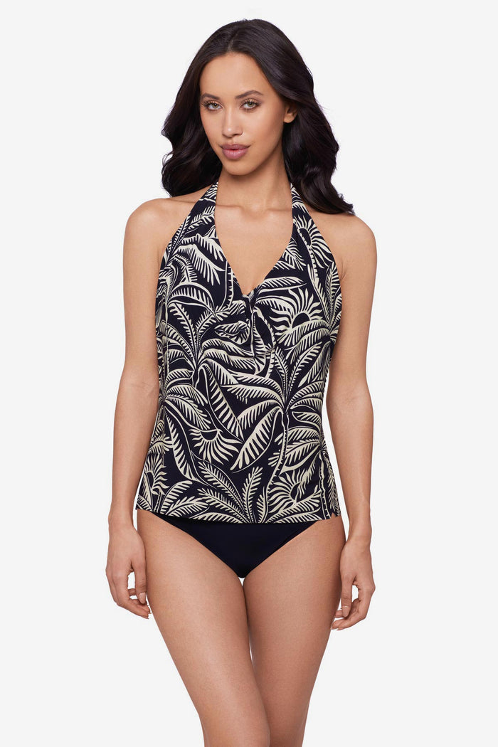 Woman wearing a black and white palm leaf printed tankini top with a V neckline