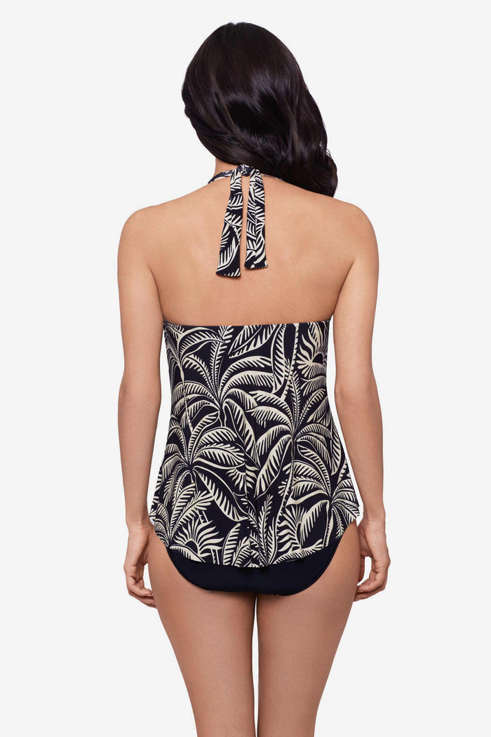 Woman wearing a black and white palm leaf printed tankini top with a halter tie