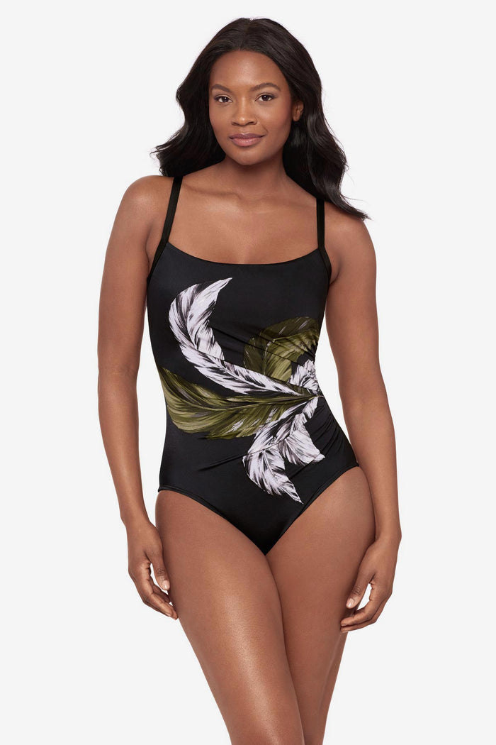 Woman wearing a green and white feather printed one-piece swimsuit