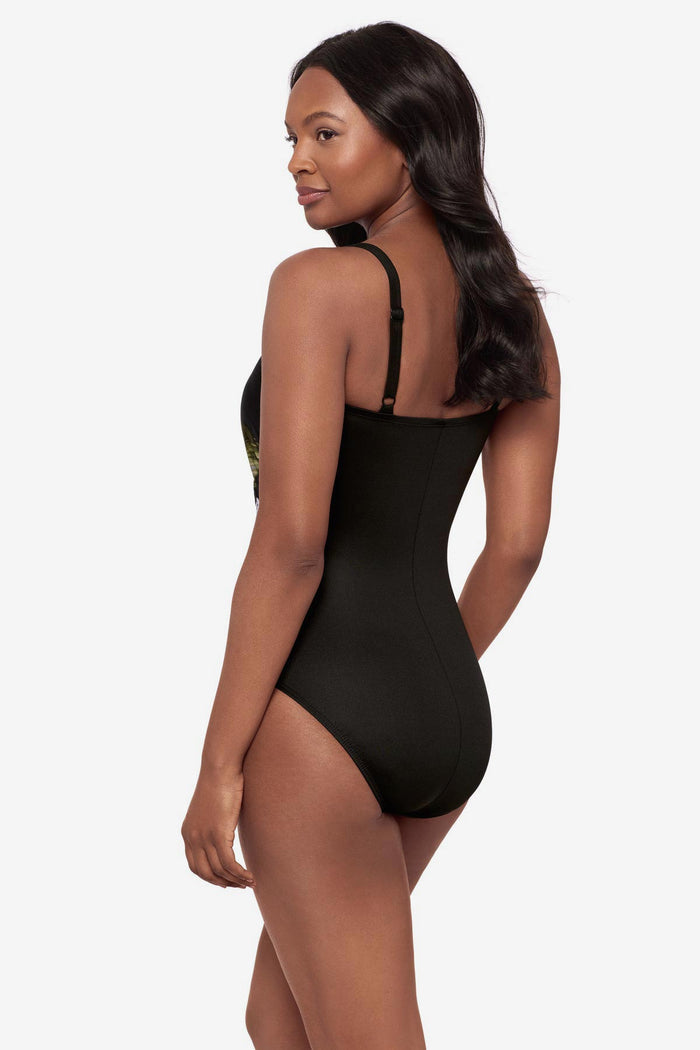 Woman turned left wearing a green and white feather printed one-piece swimsuit