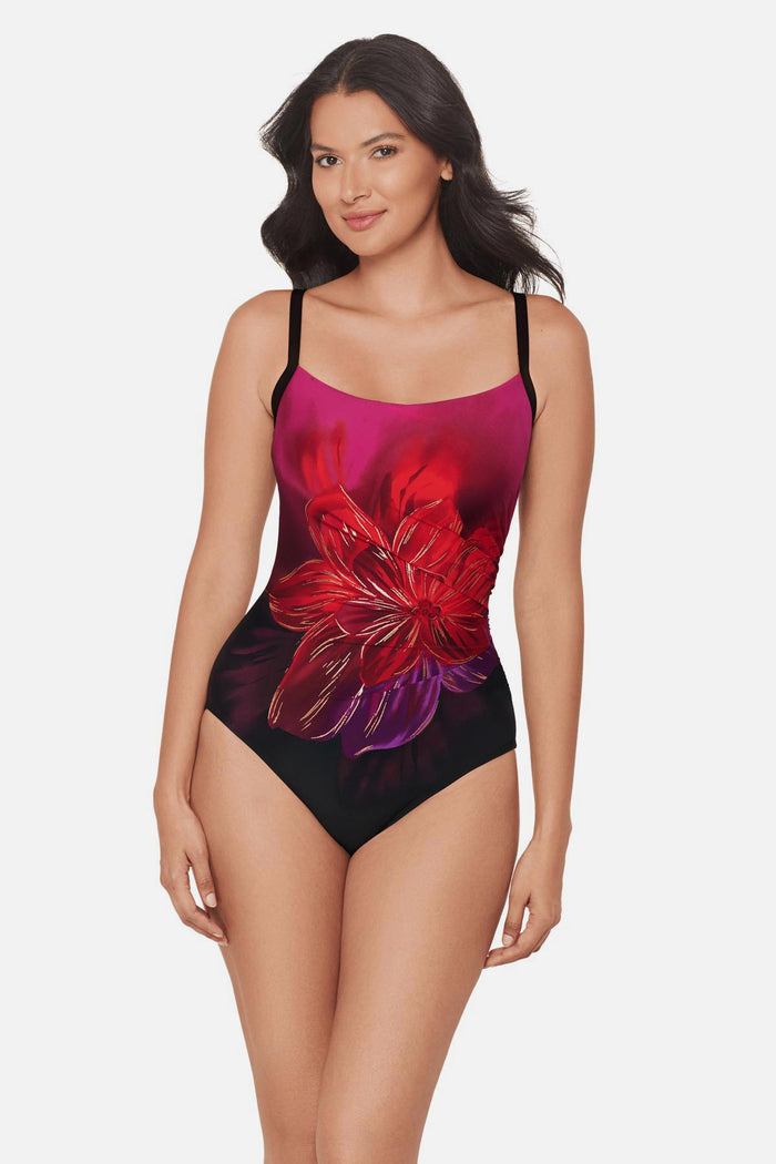 Woman wearing a red, pink and purple floral printed one-piece swimsuit with and ombre gradient