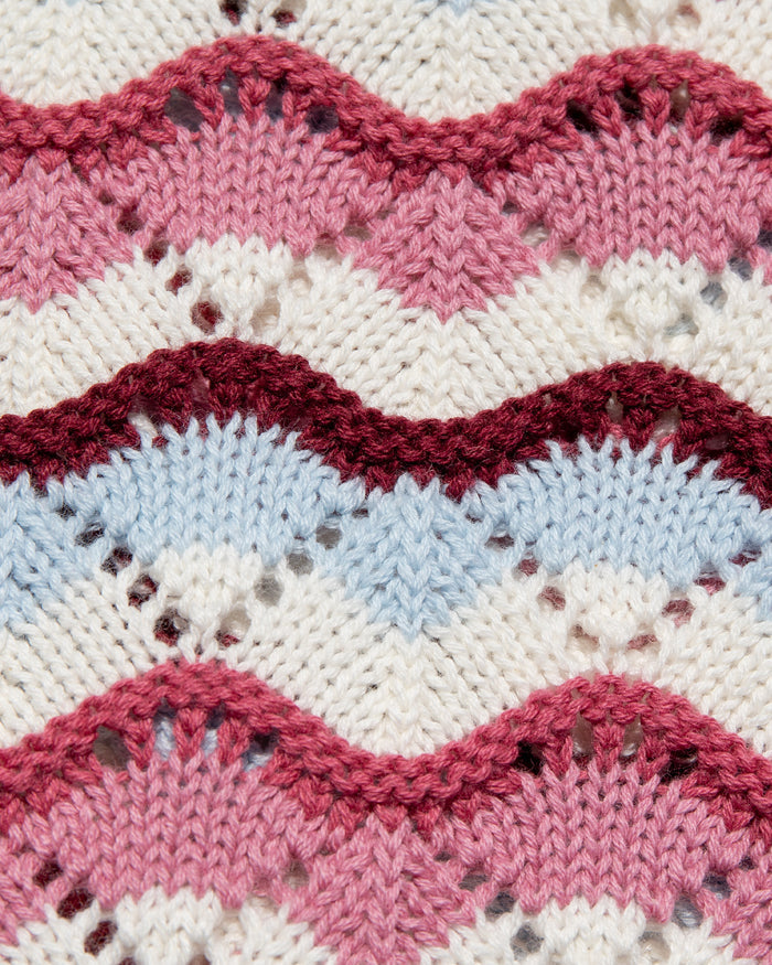 Close-up detail of the LSPACE sand in hand Sunchaser Short crochet knit fabric, showing the wavy stripe texture in pink, burgundy, blue, and cream.