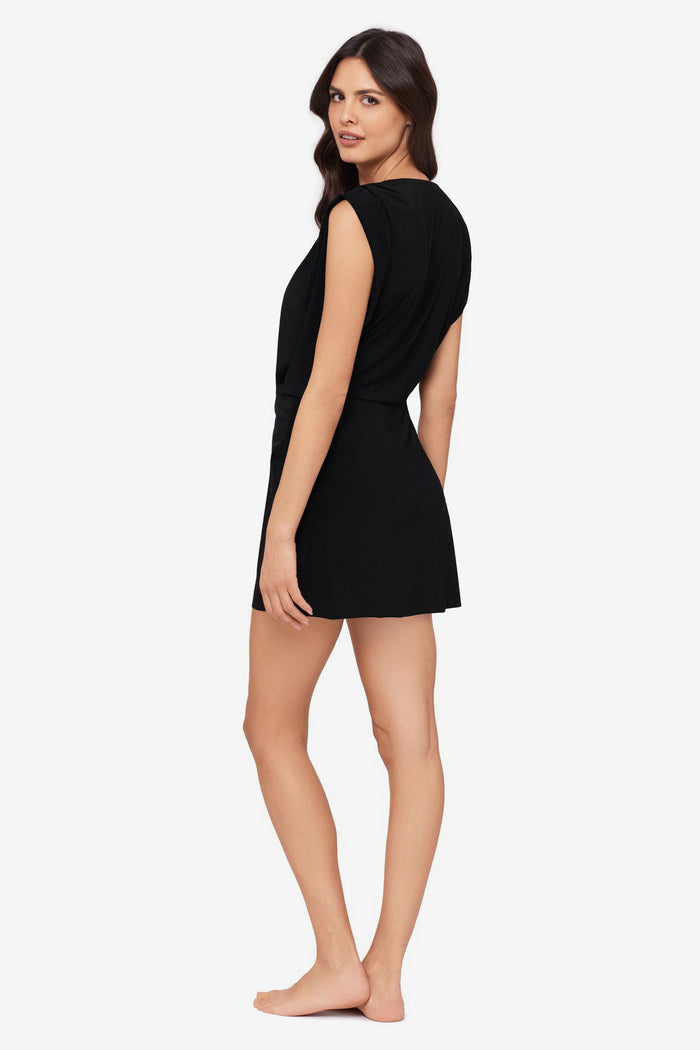 Woman turned left wearing a black swim dress cover up with a V neckline