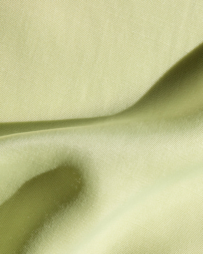 Close-up of the LSPACE Sweet As Honey Skirt in honeydew, highlighting the smooth satin fabric texture and sheen.