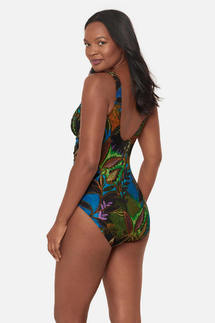 Woman turned left wearing a multicolored abstract tropical printed one-piece swimsuit