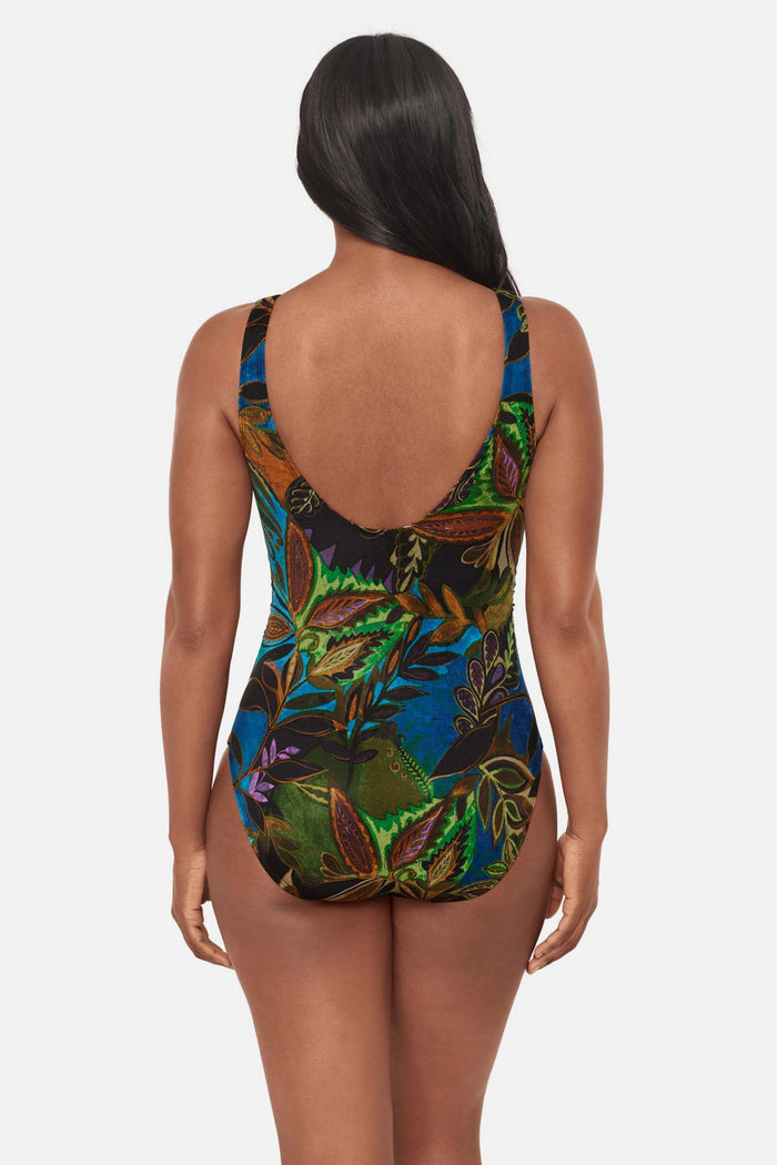 Woman faced away wearing a multicolored abstract tropical printed one-piece swimsuit