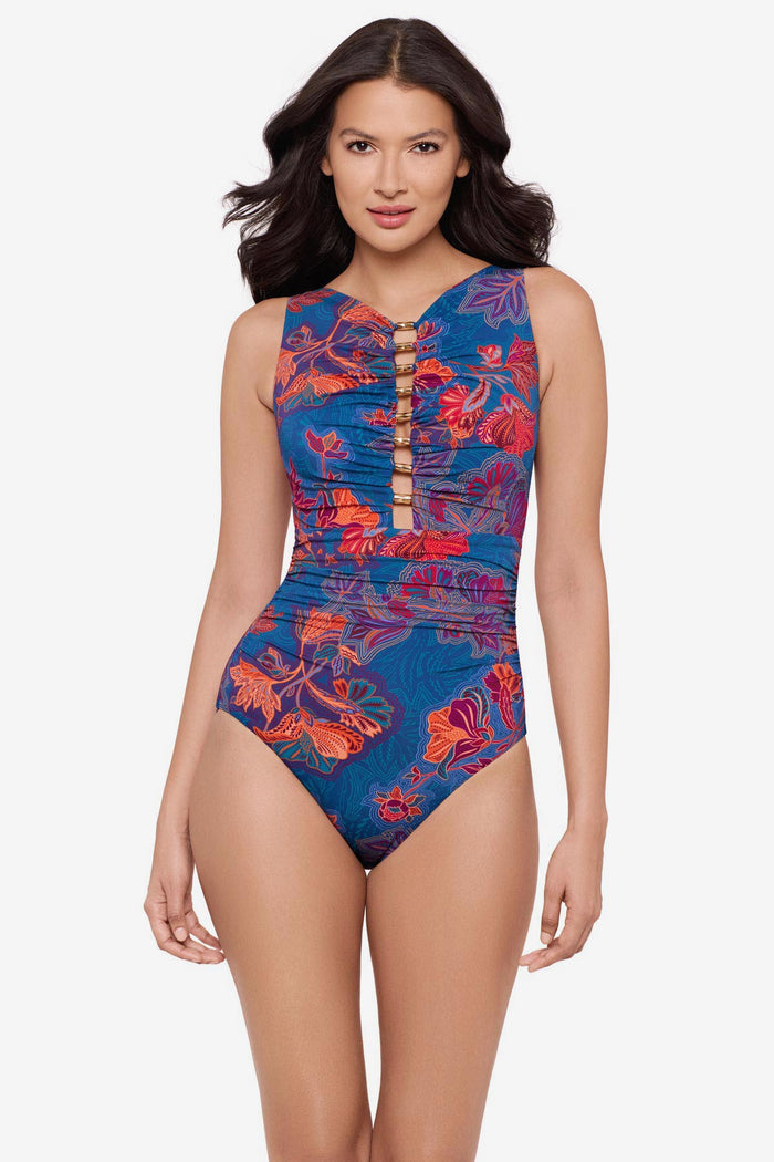 Woman wearing a multicolor one-piece swimsuit with embellishments down the front