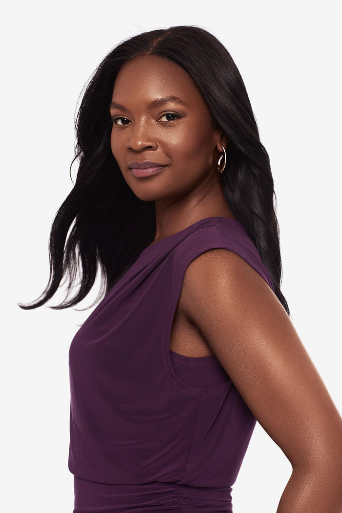 Close up of a woman wearing a plum-colored blouse