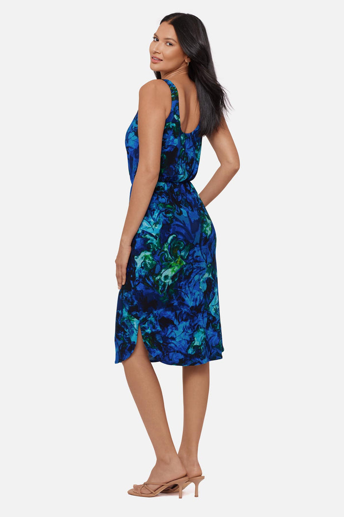 Woman turned left wearing a blue celestrial printed sleeveless mid length dress
