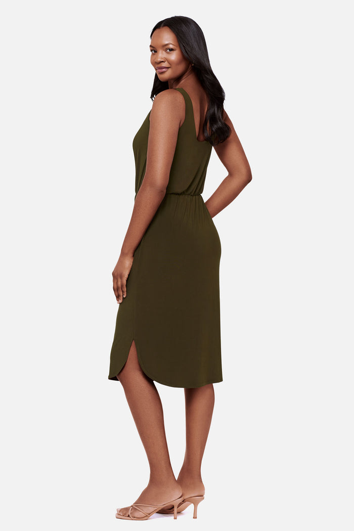 Woman faced left wearing a sleeveless green mid length dress