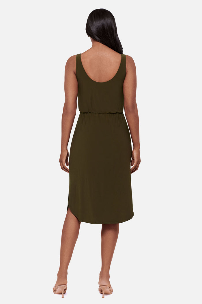 Woman faced away wearing a sleeveless green mid length dress