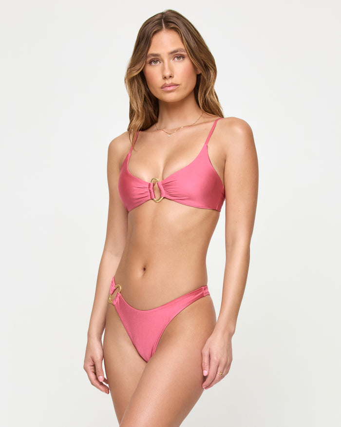 Front view of a model wearing the LSPACE begonia Teagan Bikini Bottom with gold ring hardware detail on the hip.