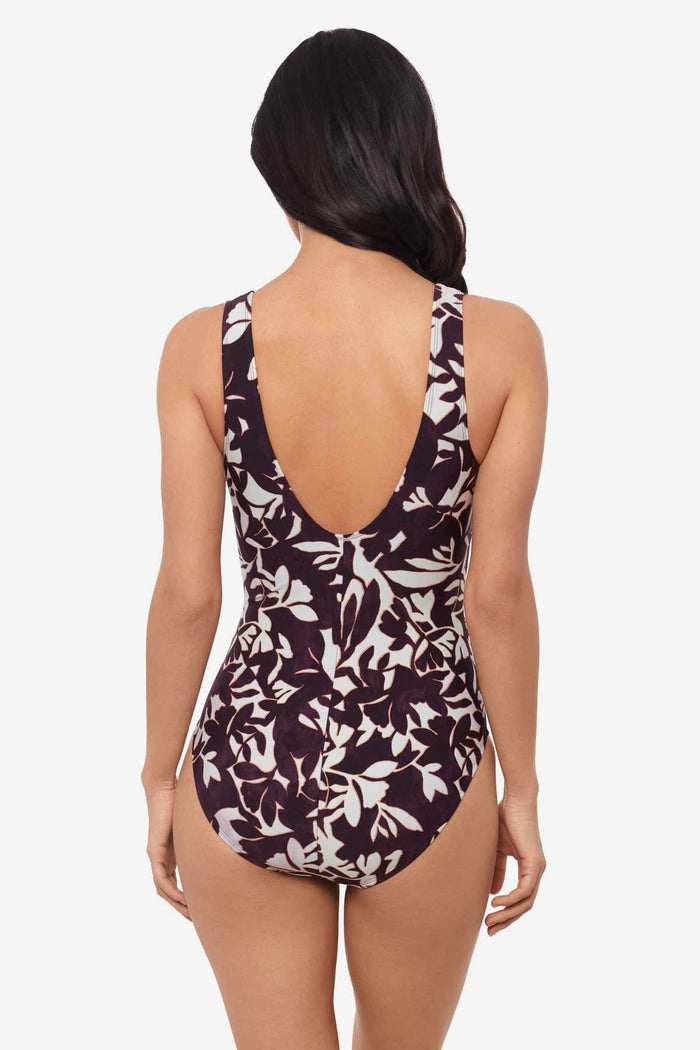 Woman facing away wearing a multicolor one-piece swimsuit