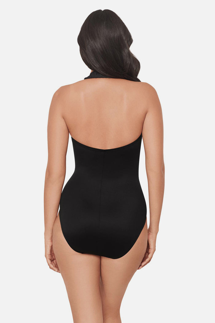 Woman turned away wearing a black one-piece swimsuit with bead details in the front