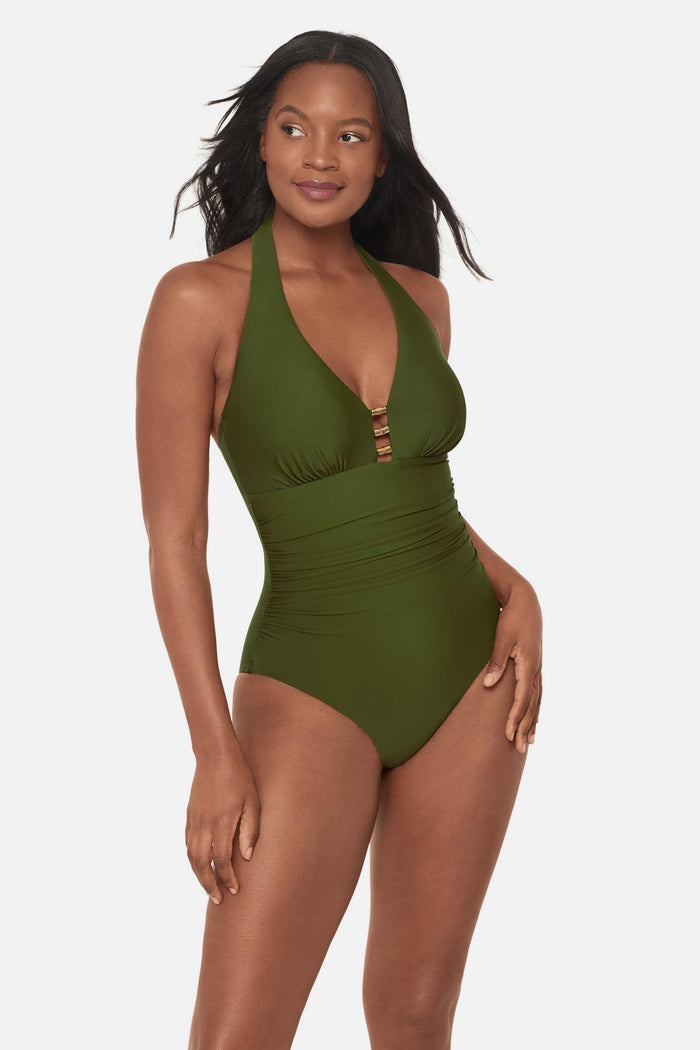 Woman wearing a green one-piece swimsuit with bead details in the front