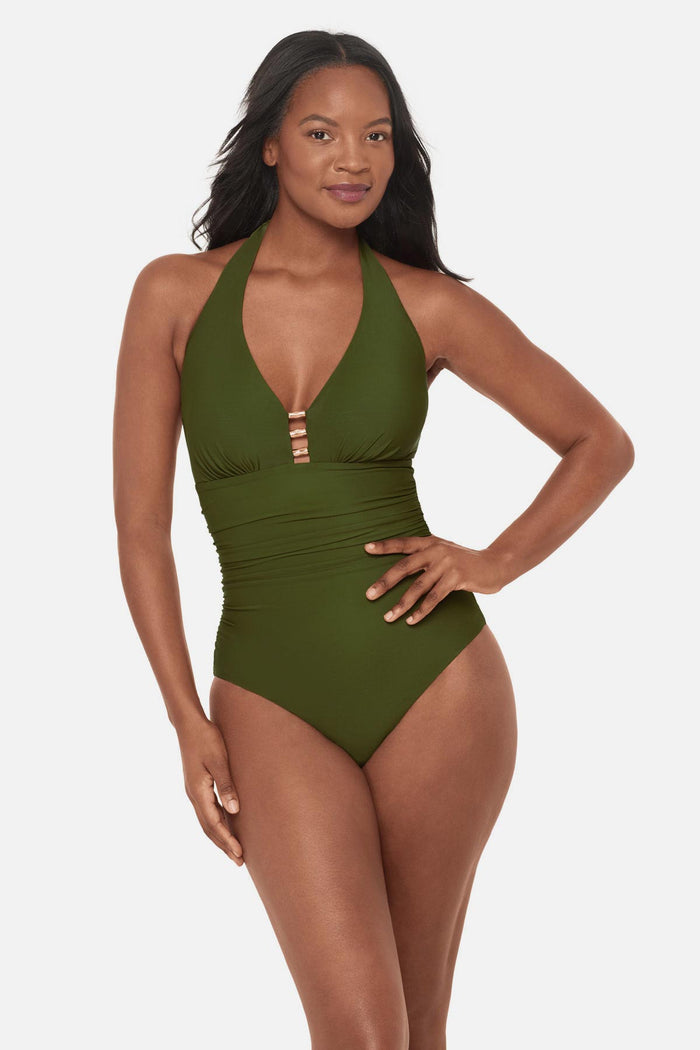 Woman wearing a green one-piece swimsuit with bead details in the front