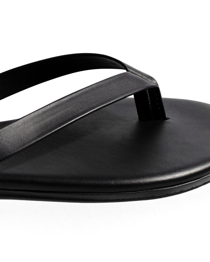 Close-up of the TKEES Boyfriend Sandals in black showing the thong strap and leather footbed detail.