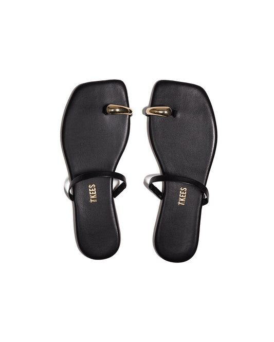 Top-down view of both black TKEES Colette Sandals with gold dome toe hardware.