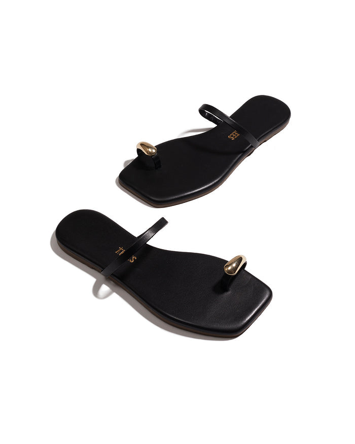 Angled view of both black TKEES Colette Sandals showing the thong strap and footbed.