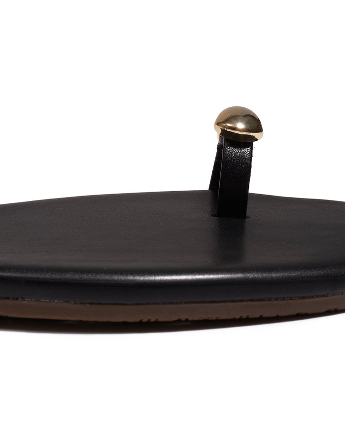 Close-up of the gold dome toe hardware on the black TKEES Colette Sandals.