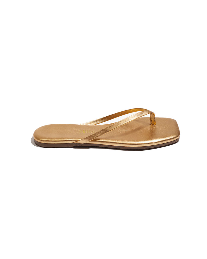 Side view of the TKEES Square Toe Lily Sandals in blink showing the gold metallic strap and square toe.