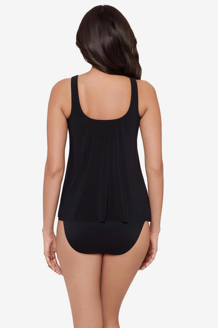 Woman turned away wearing a green and white feather printed tankini top
