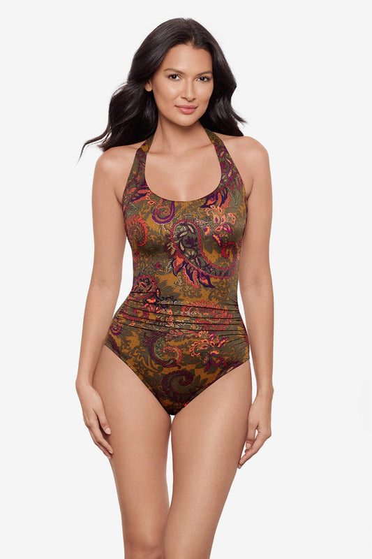 Woman wearing a halter one-piece swimsuit with brown paisley print