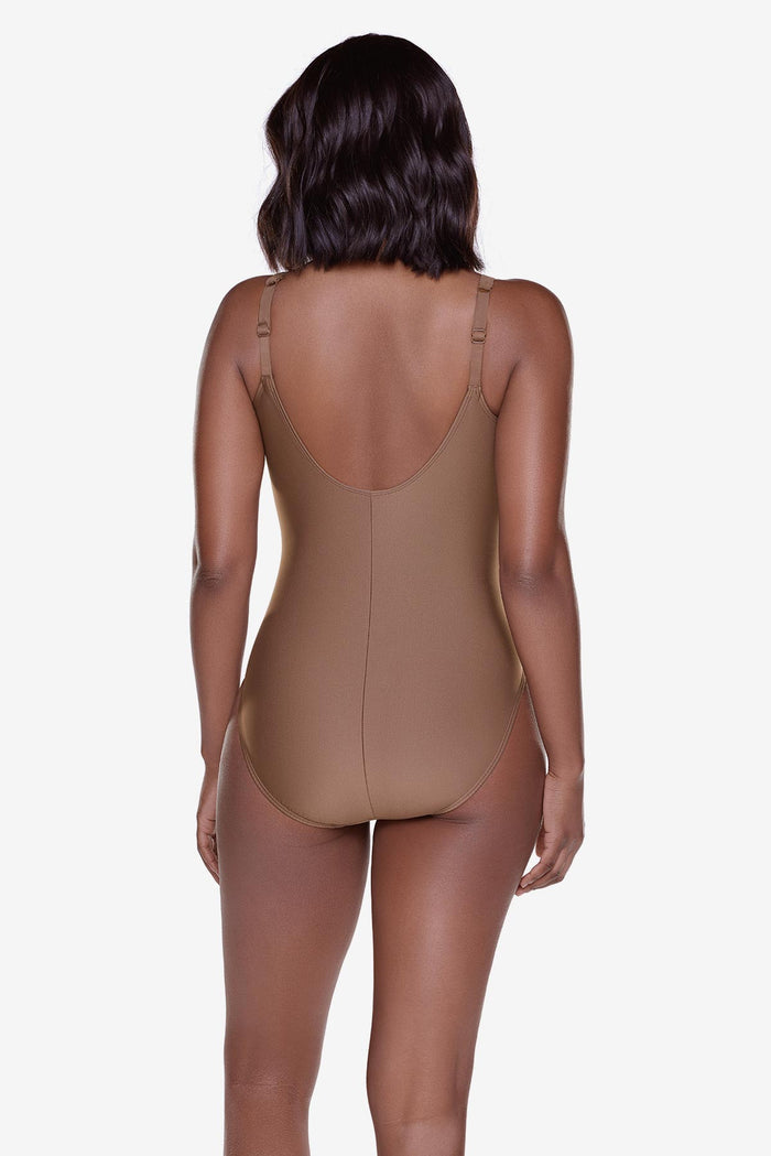 Woman turned away wearing a solid brown one piece swimsuit