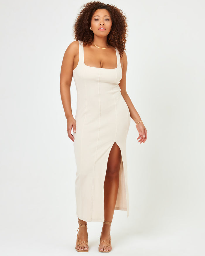 Front view of a model wearing the LSPACE Vivienne Dress in bone, a fitted midi dress with a square neckline and a side slit.