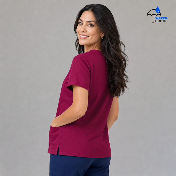 Women's FW 502 Fuchsia scrub top, rear three-quarter view with side vent visible
