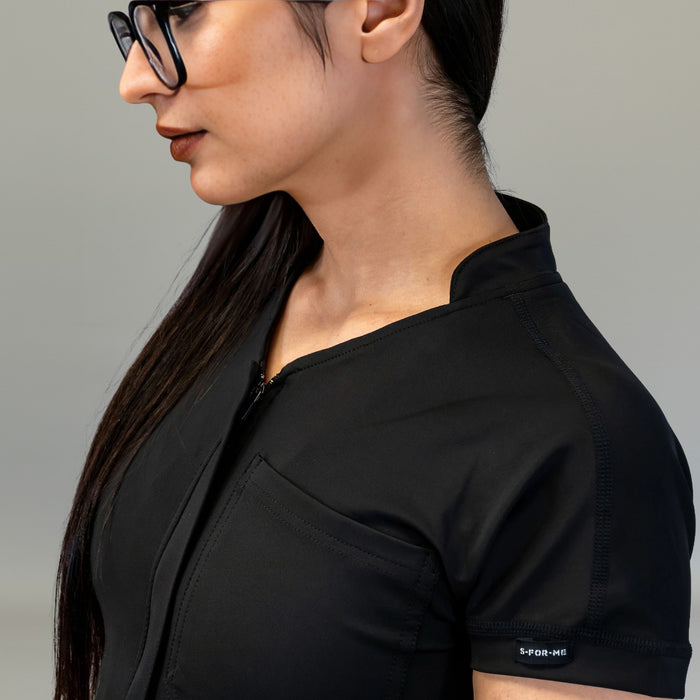 Neckline, zipper and chest pocket detail on Black scrub jumpsuit