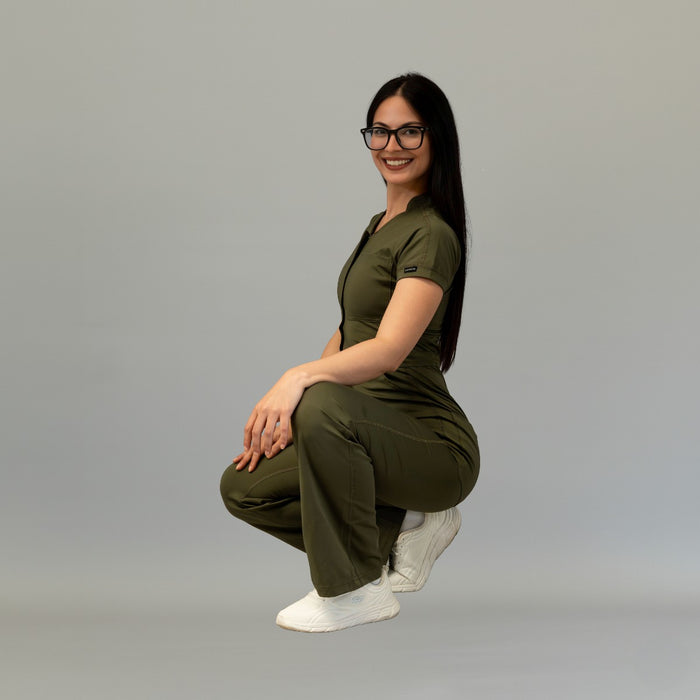 Side crouching pose in women’s Olive Green Super Stretch scrub jumpsuit