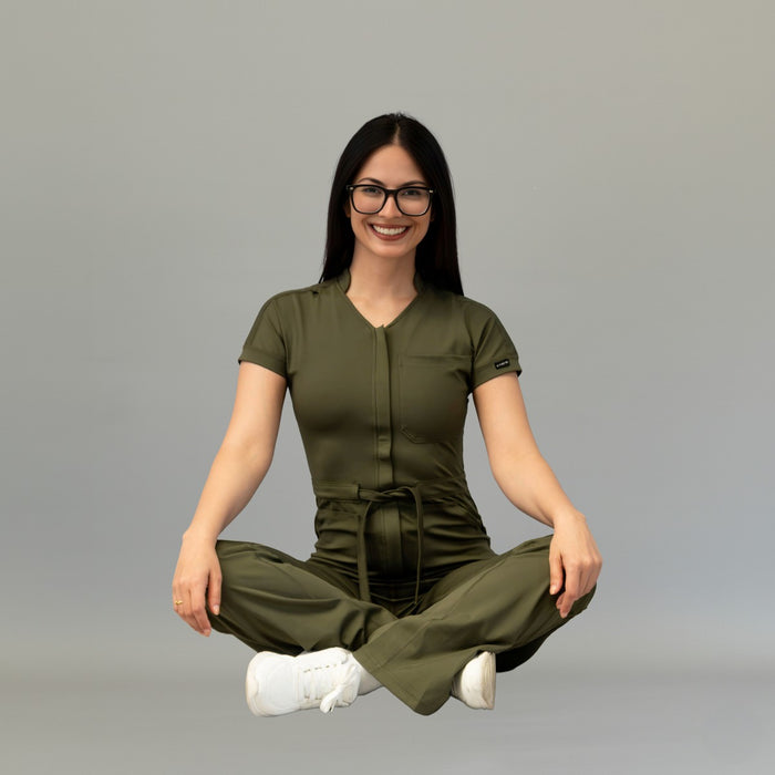 Front seated pose in women’s Olive Green Super Stretch scrub jumpsuit
