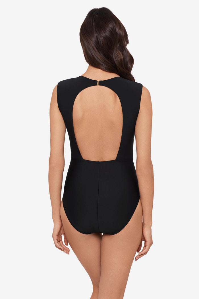 Woman turned away wearing a black one-piece swimsuit with short sleeves