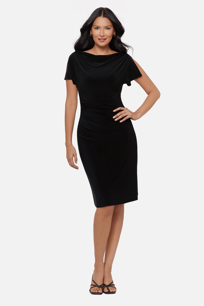 Woman wearing a black slitted short sleeve mid length dress
