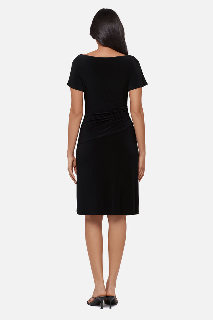Woman faced away wearing a black slitted short sleeve mid length dress