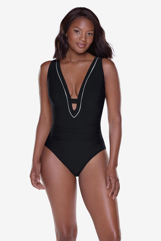 Woman wearing a black one-piece swimsuit with a deep v-neckline