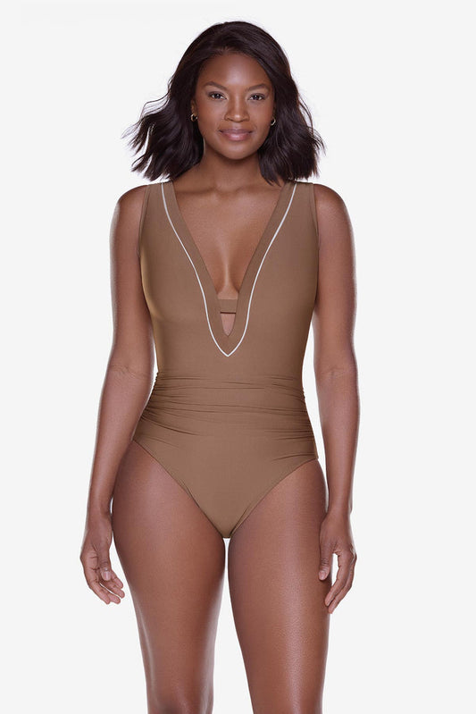Woman wearing a brown one-piece swimsuit with a deep v-neckline